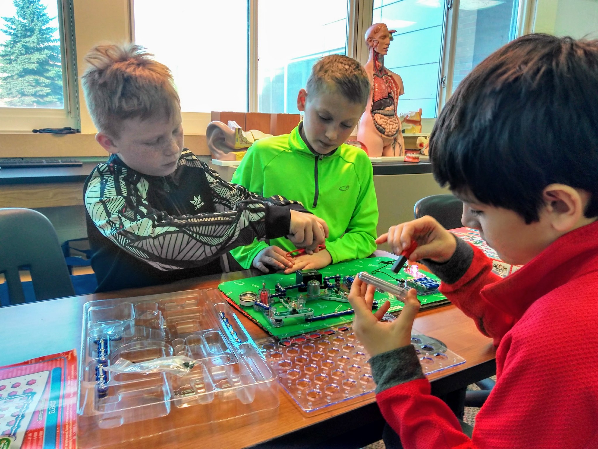 Three elementary students using snap circuits